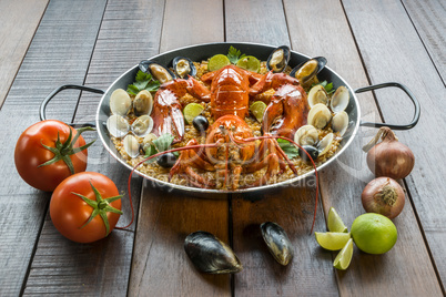 Paella with fresh lobster, clams, mussels and lime