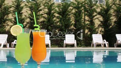 A pair of glasses with a cocktail on the poolside