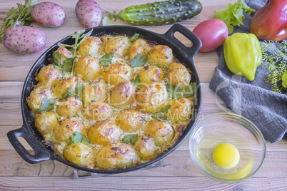 Young potatoes with cottage cheese are baked in the oven.