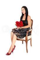 Woman sitting in armchair with red roses