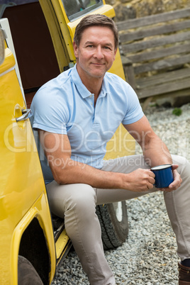 Happy Middle Aged Man Drinking Tea or Coffee Sitting In Van