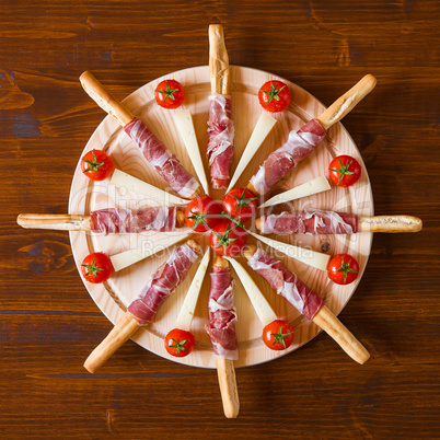 Cutting board with ham cherry tomatoes and cheese