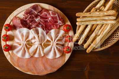 Italian cutting board and breadsticks on a wicker basket