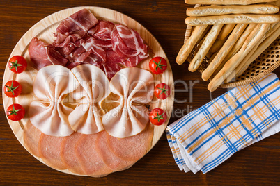 Salami cutting board breadsticks and napkin