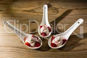 Mascarpone cream and strawberries on ceramic spoons