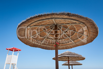 Life guard stand and three beach umbrellas