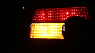 Flashing Car Light on Urban Road at Night