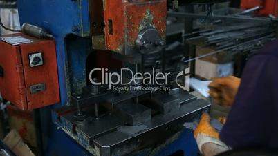 Factory Worker Drilling Metal Parts with a Machine