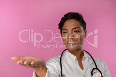 Smiling nurse shows a copy space with open hand