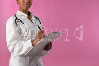 professionnal nurse with a pink ribbon writing on a note pad