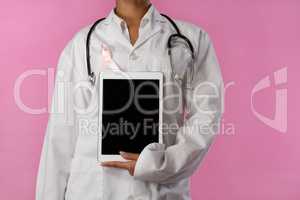 Nurse wearing pink ribbon holding a tablet in her hand