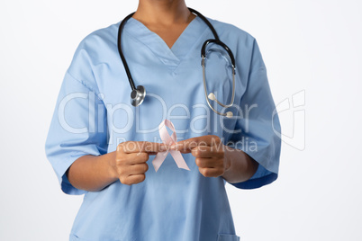 Nurse holding breast cancer awareness pink ribbon with both hands