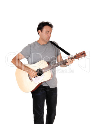 A tall man standing with his guitar and playing