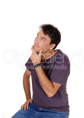 Puzzled young man with his hand on chin