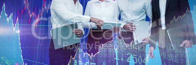 Composite image of business people holding files discussing over tablet