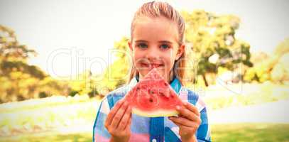 Smiling girl holding watermelon slice in the park