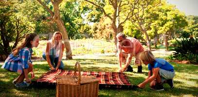 Family spreading the picnic blanket