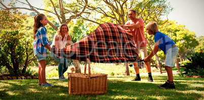 Family spreading the picnic blanket