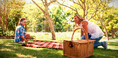 Mother and daughter spreading the picnic blanket Mother and daughter spreading the picnic blanket