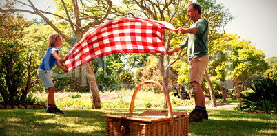 Father and son spreading the picnic blanket