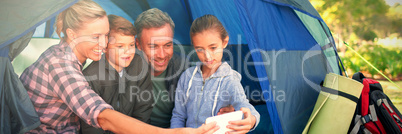 Family taking a selfie in the tent at campsite