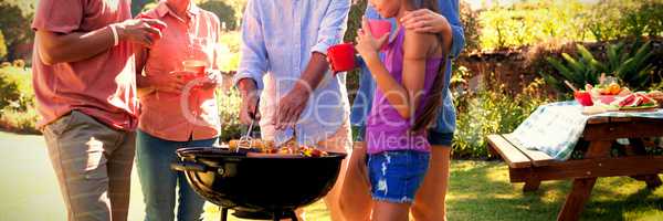 Family talking while preparing barbecue in the park