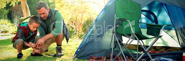 Father and son setting up a tent