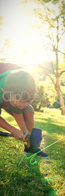 Boy setting up the tent at campsite