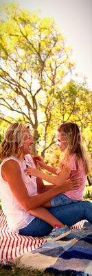 Happy mother embracing her daughter in park