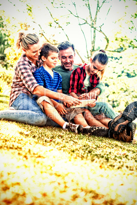 Family using digital tablet in the park