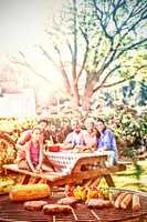 Close-up of barbecue and family sitting on the table