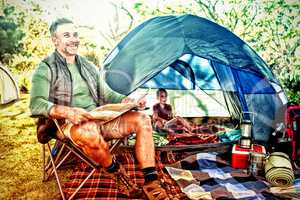 Man reading the map outside the tent at campsite