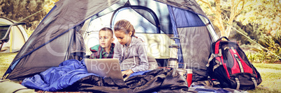 Kids using laptop in the tent