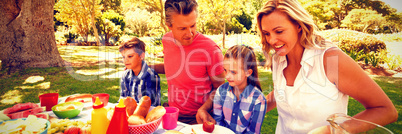 Happy family having meal in park