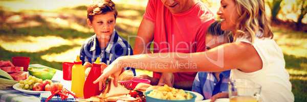 Happy family having meal in park