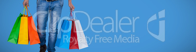 Composite image of portrait of young man carrying colorful shopping bag against white background