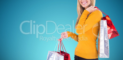 Composite image of stylish blonde smiling with shopping bags