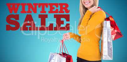Composite image of stylish blonde smiling with shopping bags