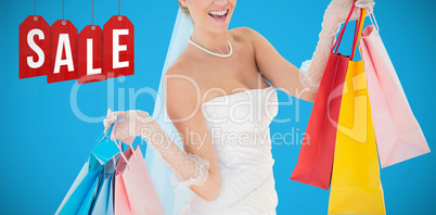 Composite image of bride holding shopping bags over white background