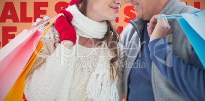 Composite image of couple with shopping bags