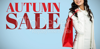 Composite image of woman with christmas hat holding red shopping bag