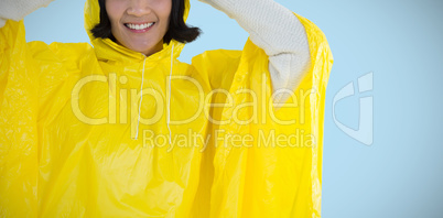 Composite image of woman wearing yellow raincoat against white background