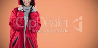 Composite image of smiling woman in hooded jacket standing against white background