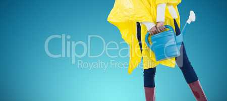 Composite image of woman in yellow raincoat holding an watering can
