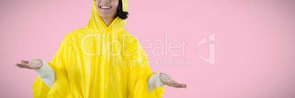 Composite image of woman in yellow raincoat gesturing to feel the rain