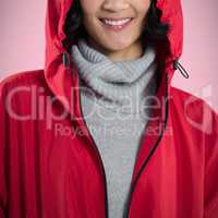 Composite image of smiling woman in hooded jacket standing against white background