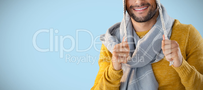Composite image of portrait of smiling man holding wooly hat