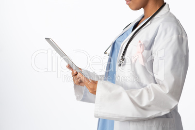 female doctor wearing breast cancer awareness pink ribbon holding a tablet