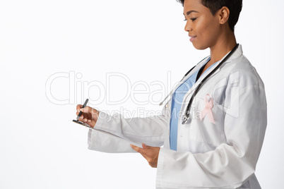 Female doctor wearing breast cancer awareness pink ribbon writing on a note pad