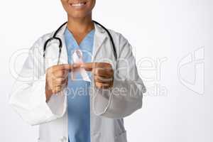 Smiling female doctor holding breast cancer awareness pink ribbon